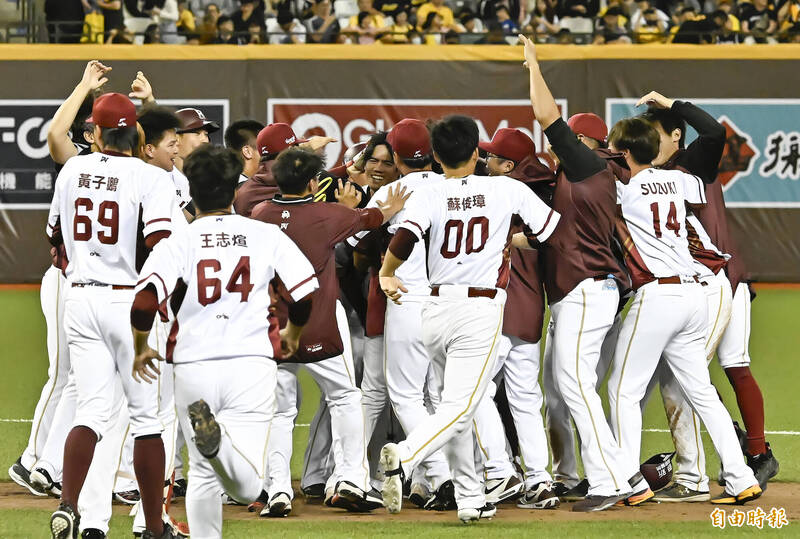 樂天桃猿林智平敲出再見安打，結束比賽，隊友衝到場上開心慶祝。（記者陳志曲攝）