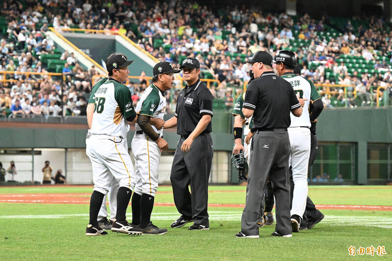 洪一中總教練抗議漏踩壘包，衝上去與主審裁判發生推擠衝突。（記者李惠洲攝）