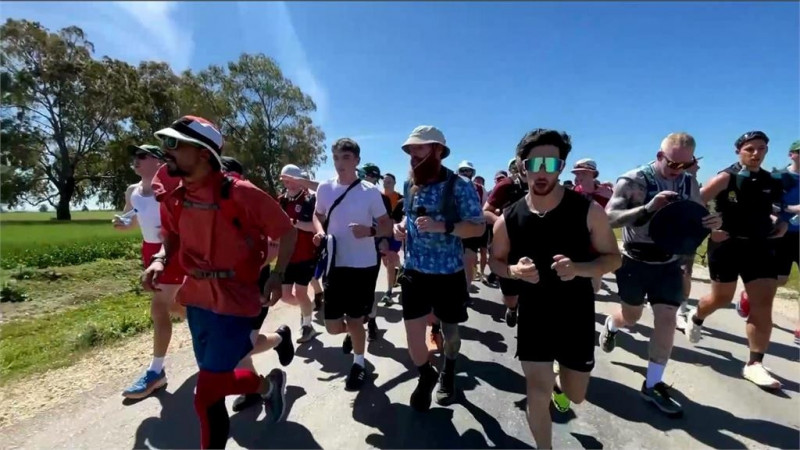 完美復刻電影「阿甘正傳」經典畫面，眾人陪庫克跑。（路透）