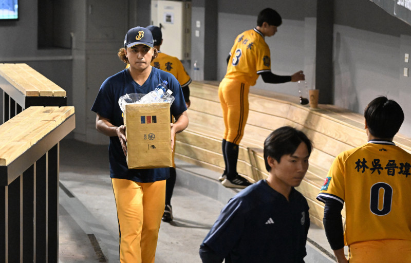 余謙和隊上年輕隊友一起收拾休息室。（記者林正堃攝）