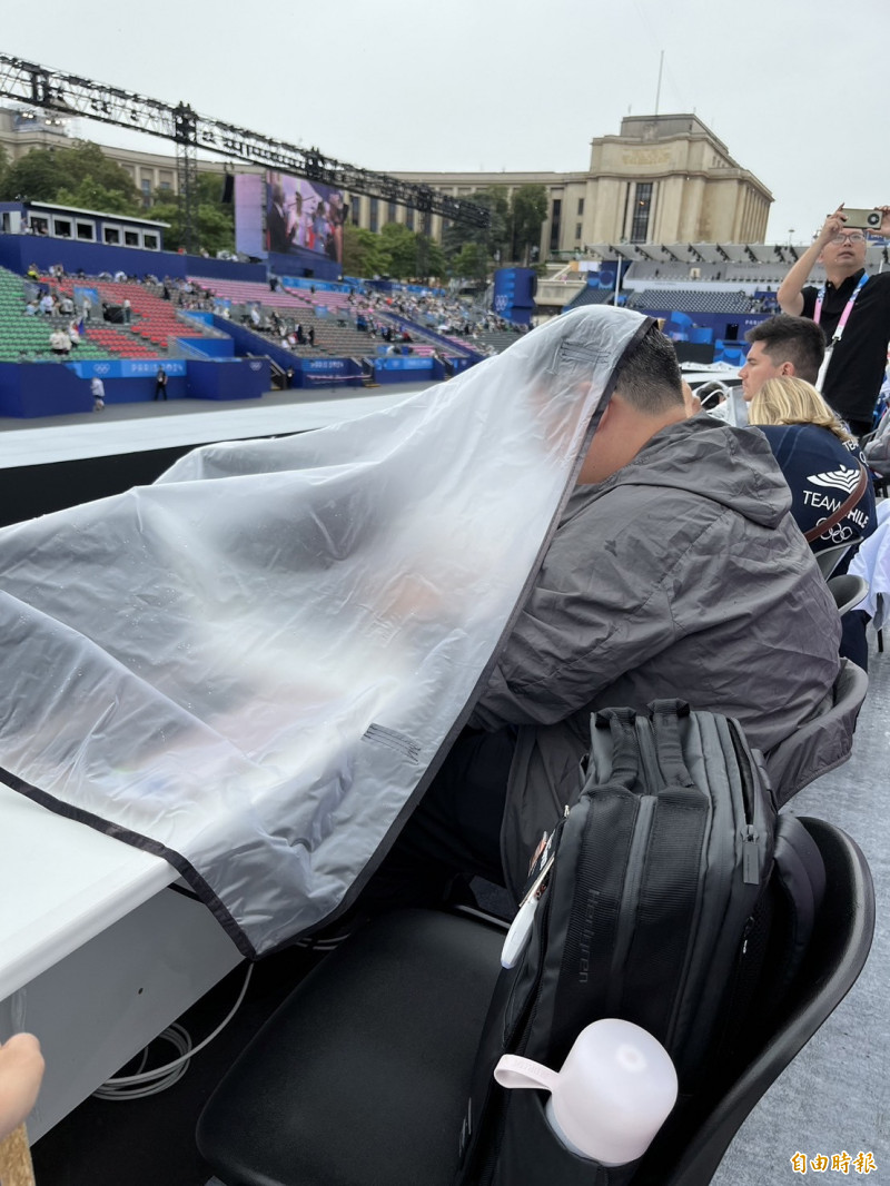 媒體在雨中工作，只能靠帆布擋雨。（特派記者粘藐云攝）