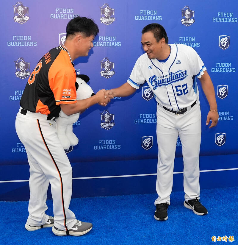 富邦悍將總教練陳金鋒（右）送上史努比大布偶給統一獅潘威倫（左）。（記者陳志曲攝）