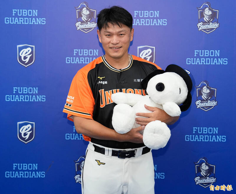 統一獅潘威倫拿著鋒總送的史努比大布偶，臉上露出笑容。（記者陳志曲攝）