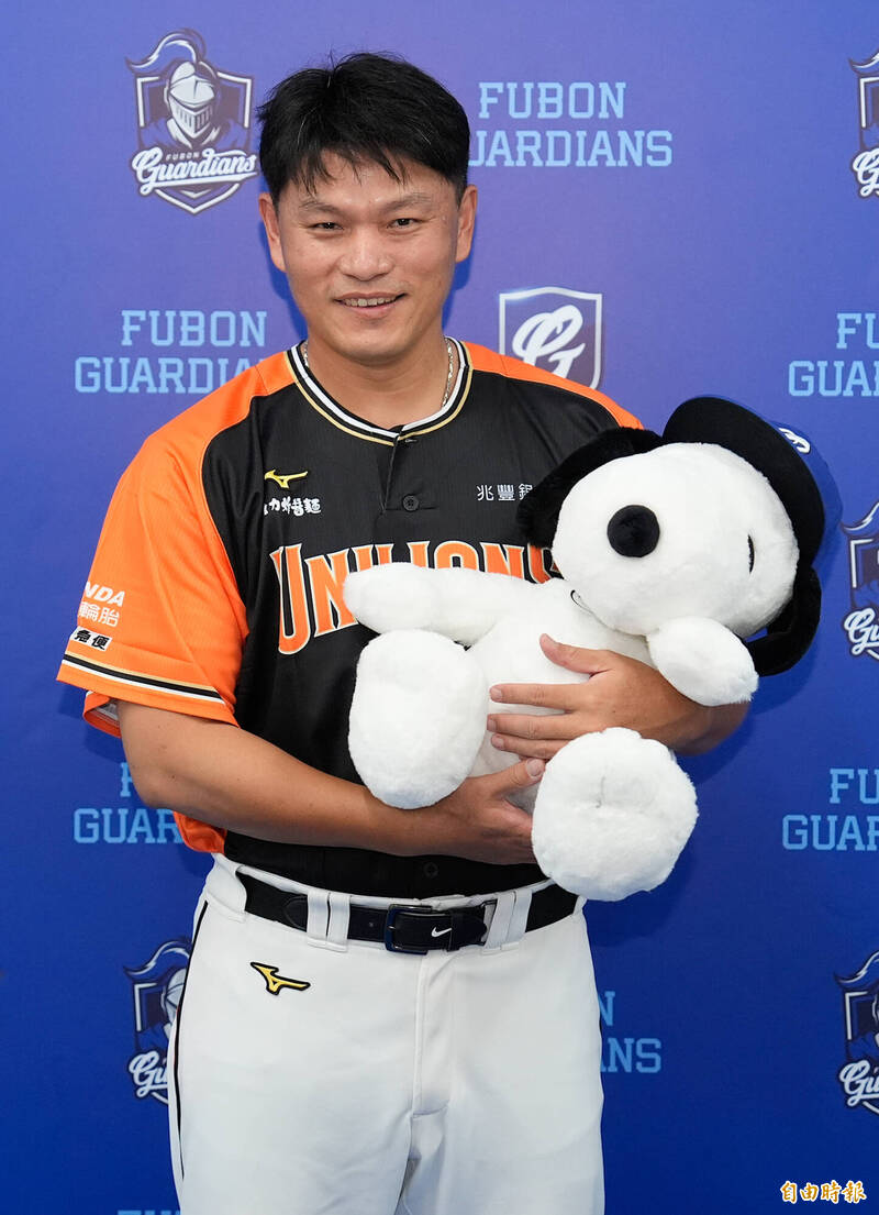 統一獅潘威倫拿著鋒總送的史努比大布偶，臉上露出笑容。（記者陳志曲攝）