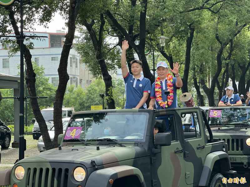 李洋（左）在父親李峻淯（右）及母親、哥哥陪同下車巡向沿途歡迎民眾揮手致意，金防部出動軍用吉普車支援。（記者吳正庭攝）