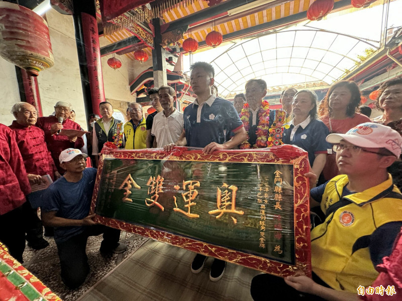 李洋（中）回到金門南山大祖厝，敬獻「奧運雙金」匾額。（記者吳正庭攝）