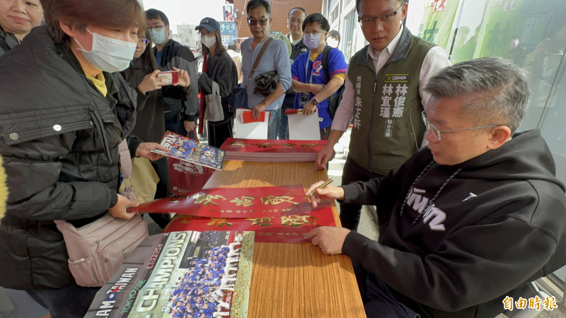 中職會長蔡其昌（右）到台南永康發送「台灣尚勇」春聯，民眾排隊等候簽名。（記者劉婉君攝）