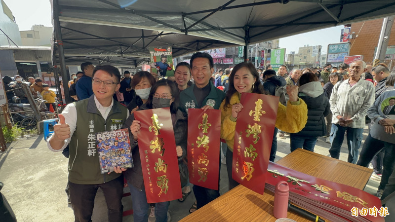 立委林宜瑾、林俊憲（右1、2）與市議員朱正軒（左1）一同發送「台灣尚勇」春聯給排隊民眾。（記者劉婉君攝）