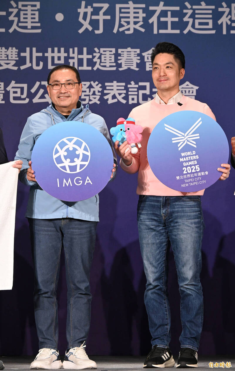 新北市長侯友宜與台北市長蔣萬安七日共同出席2025雙北世界壯年運動會服裝暨禮包公開記者會，兩人分別穿著藍色及粉紅色上衣搭配吉祥物「壯寶」的配色，歡迎各界報名參與盛會。（記者劉信德攝）