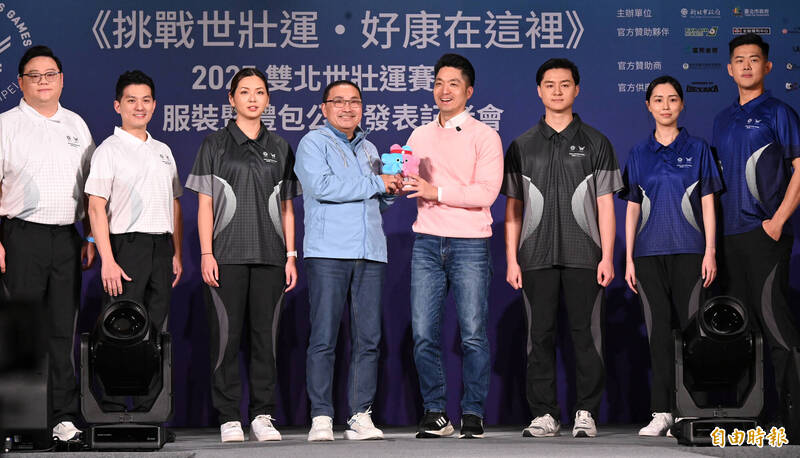 新北市長侯友宜與台北市長蔣萬安七日共同出席2025雙北世界壯年運動會服裝暨禮包公開記者會，兩人分別穿著藍色及粉紅色上衣搭配吉祥物「壯寶」的配色，歡迎各界報名參與盛會。（記者劉信德攝）