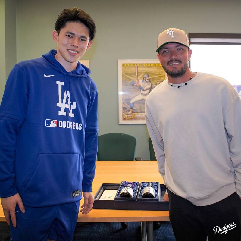 佐佐木朗希（左）贈送清酒給羅哈斯（右）。（取自道奇社群媒體X）