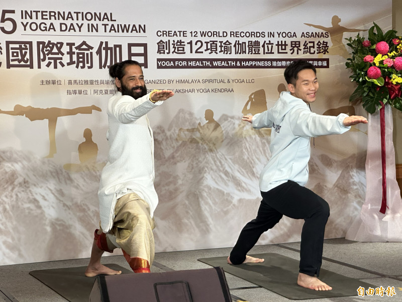 李洋（右）展示瑜伽動作，也與阿克夏爾上師互相贈禮。（記者盧養宣攝）