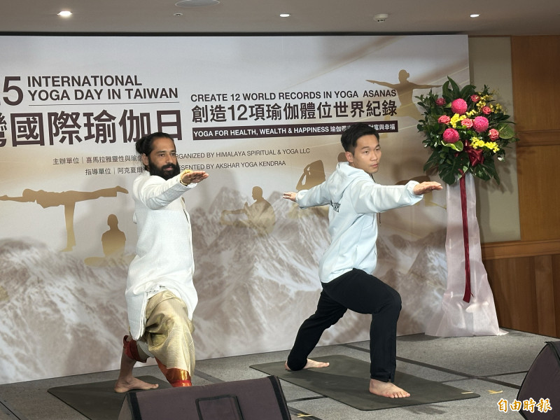 李洋（右）展示瑜伽動作，也與阿克夏爾上師互相贈禮。（記者盧養宣攝）