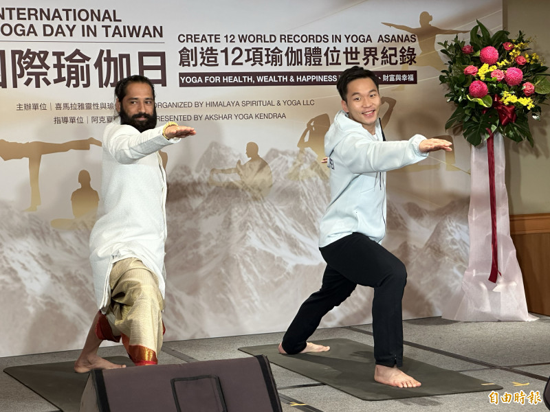 李洋（右）展示瑜伽動作，也與阿克夏爾上師互相贈禮。（記者盧養宣攝）