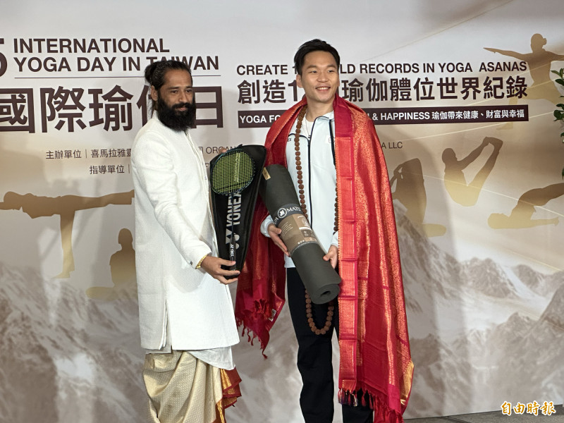 李洋（右）展示瑜伽動作，也與阿克夏爾上師互相贈禮。（記者盧養宣攝）