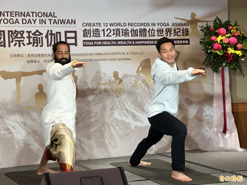 李洋（右）展示瑜伽動作，也與阿克夏爾上師互相贈禮。（記者盧養宣攝）