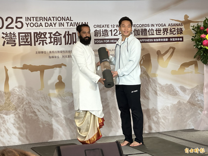 李洋（右）展示瑜伽動作，也與阿克夏爾上師互相贈禮。（記者盧養宣攝）