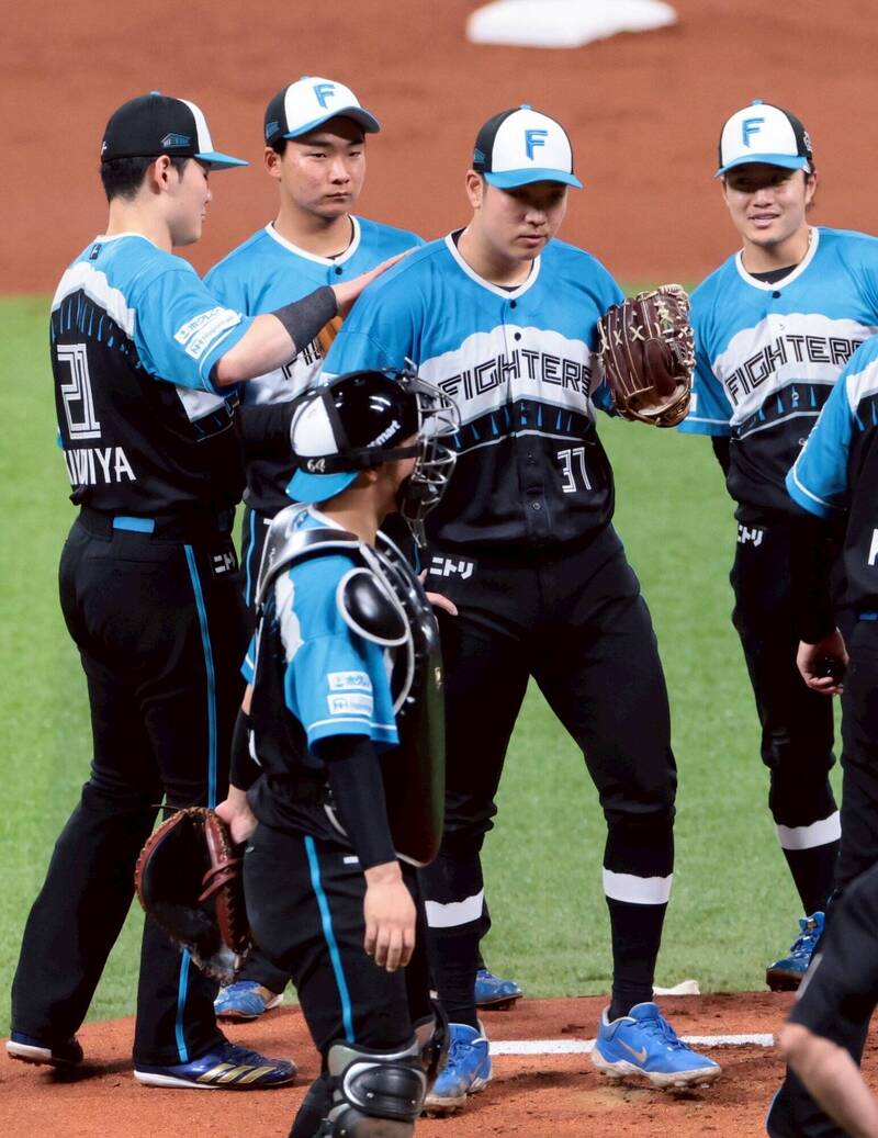 清宮幸太郎拍拍古林睿煬。（北海道新聞提供）