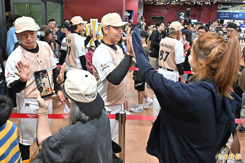 比賽因雨裁定，由樂天桃猿拿下勝利，總教練古久保健二帶著三位球員馬傑森、陳佳樂、曾冠傑與球迷擊掌揮別。（記者陳志曲攝）