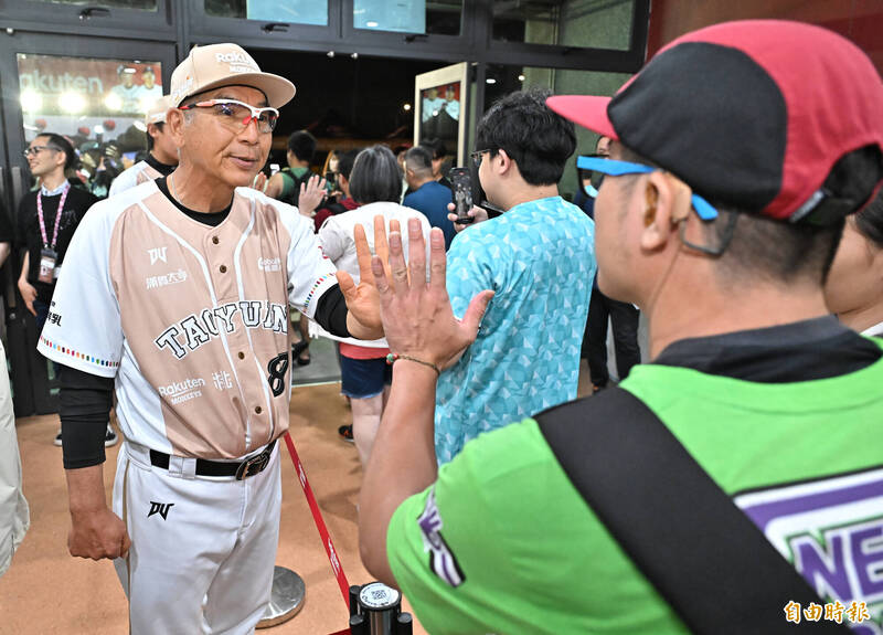 比賽因雨裁定，由樂天桃猿拿下勝利，總教練古久保健二帶著三位球員馬傑森、陳佳樂、曾冠傑與球迷擊掌揮別。（記者陳志曲攝）