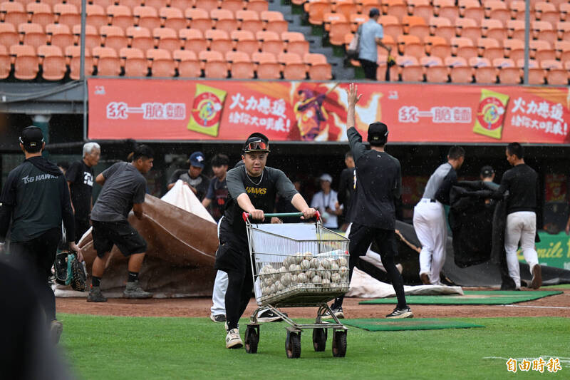 獅鷹大戰賽前因雨不停歇、蓋上帆布，確定會延後開打。（記者李惠洲攝）