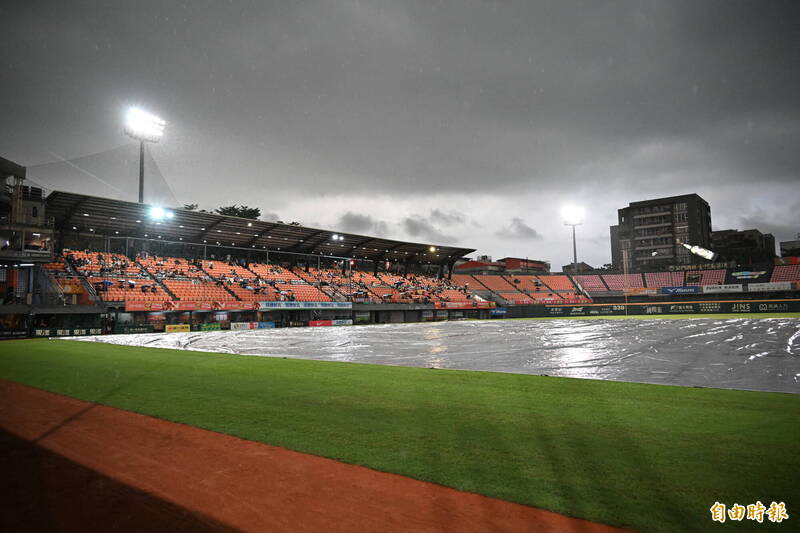 獅鷹大戰賽前因雨不停歇、蓋上帆布，確定會延後開打。（記者李惠洲攝）