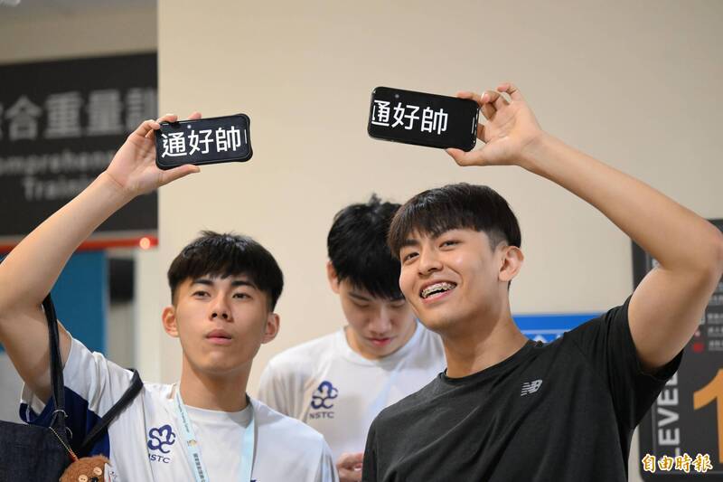隊友透過手機傳遞「陳弈通」好帥訊息。（記者李惠洲攝）