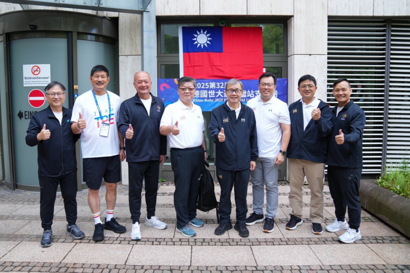 教育部長鄭英耀（右4）、體育署長鄭世忠（右3）等代表團成員與中繼站和門口懸掛的國旗（體育署提供）