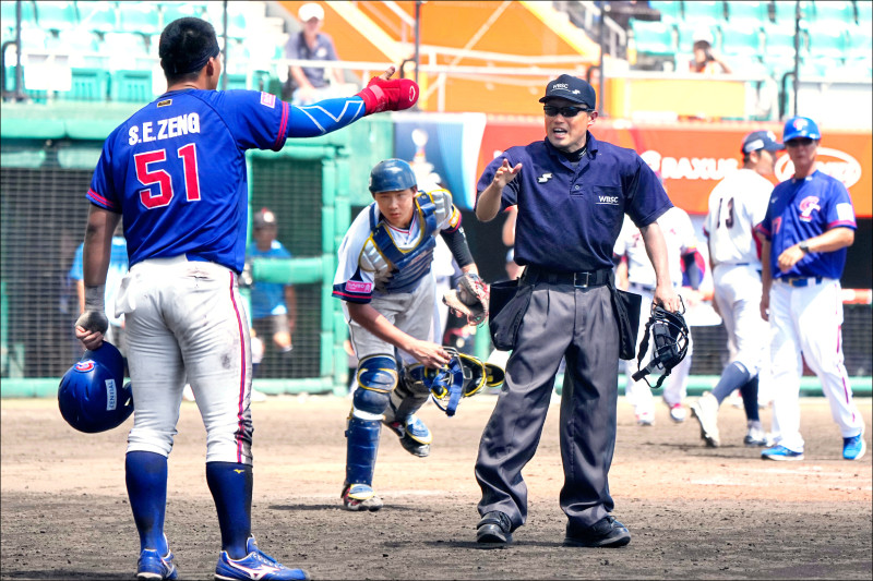 曾聖恩（左）跑回本壘遭判出局，還被趕出場，他激動地據理力爭，經過重播輔助判決改判，台灣隊拿下最重要的致勝分。（中央社）