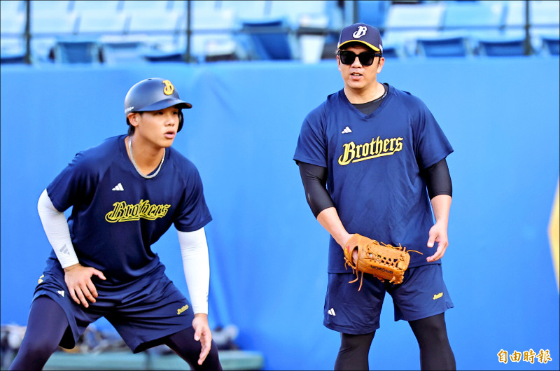 周思齊（右）昨賽前穿兄弟練習衣陪學弟練球。（記者林正堃攝）