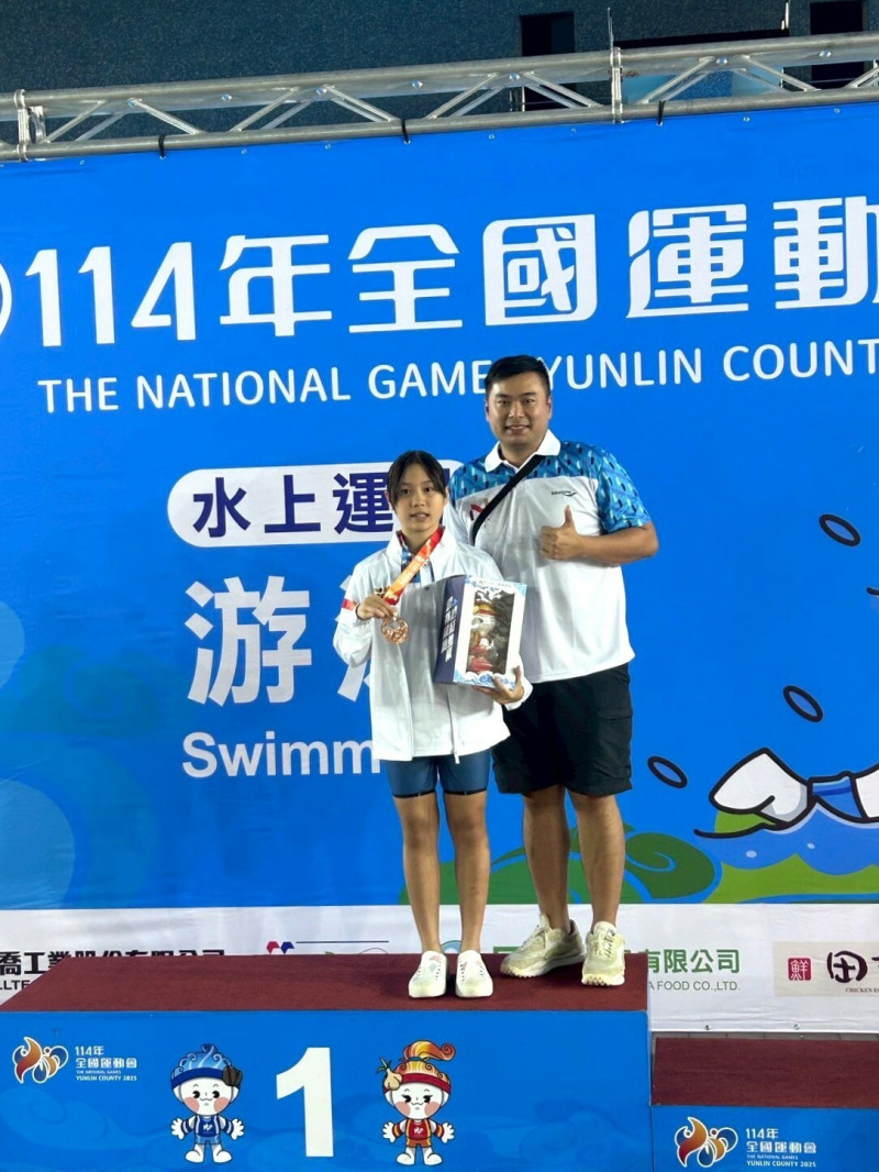 12歲游泳小將何康婗，在女子200公尺蛙式摘金，賽後與父親合影。（南市體育局提供）