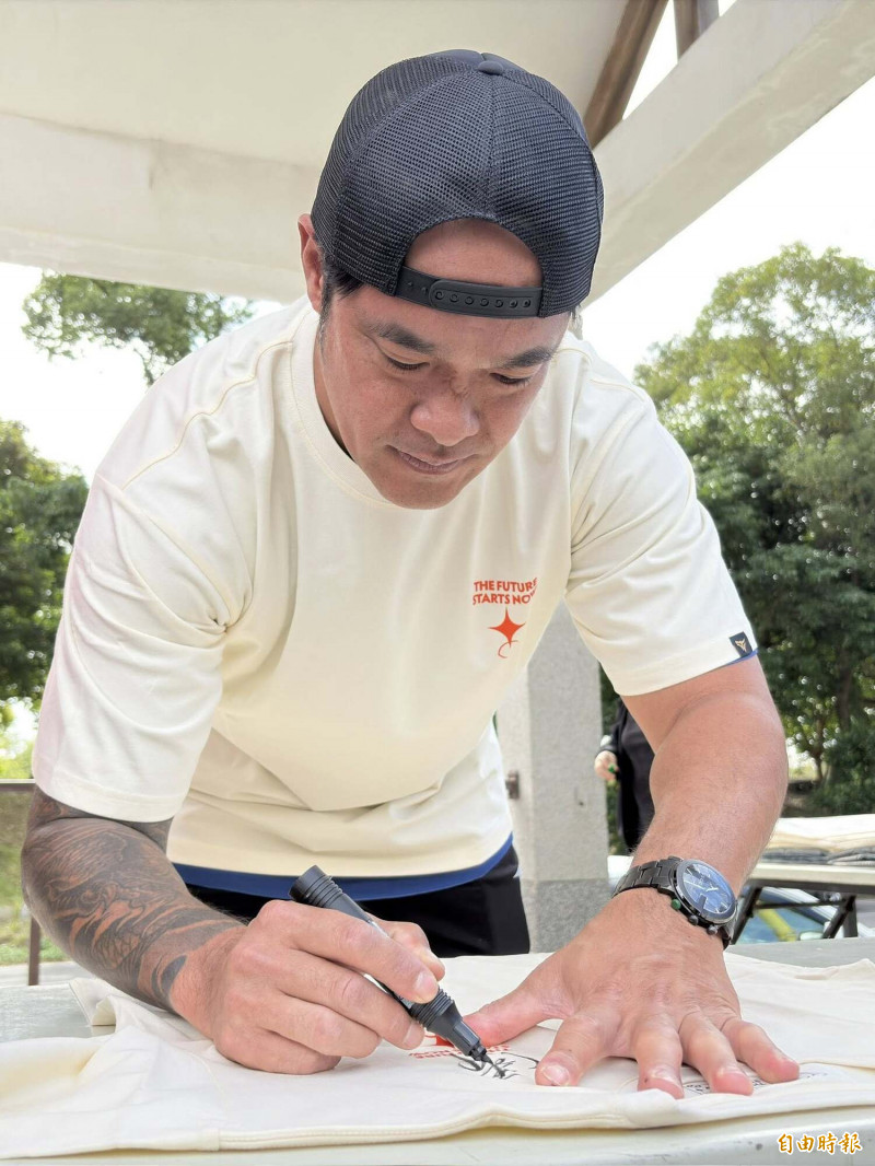 林智勝帶領原協會在關懷盃比賽場地義賣Ｔ恤，並為球迷在Ｔ恤上簽名。（記者徐正揚攝）