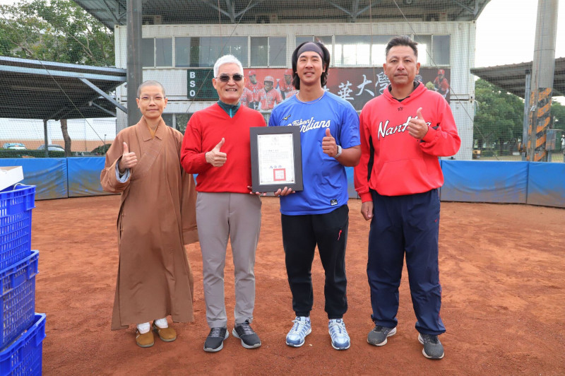 南華大學職棒校友陳鐿中（右二）捐贈10箱比賽用球回饋母校球隊，校長高俊雄（左二）致贈感謝狀。左一為南華大學駐校董事覺禹法師，右一為球隊總教練蔡仲南。（南華大學提供）