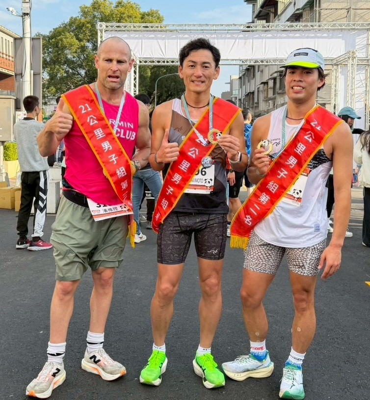 日本知名企業家嵜本晃次（中）在2026濁水溪紫金馬拉松花城竹山站奪冠，與2、3名跑者合影。（竹山鎮公所提供）