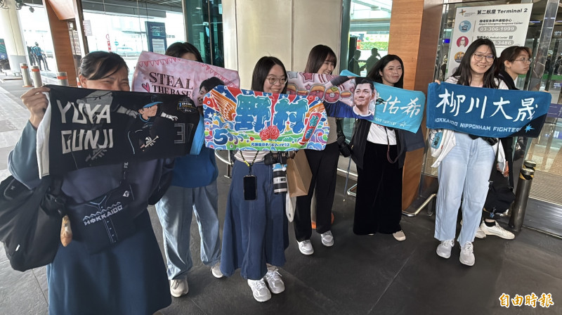 球迷高舉應援毛巾，為心儀球員加油打氣。（記者劉信德攝）