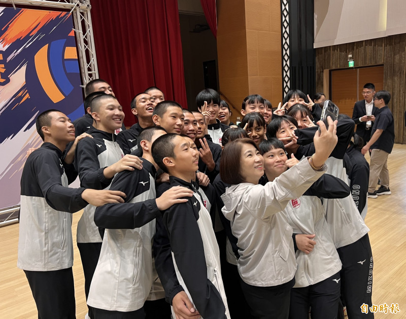 授旗典禮上，新園國中男、女排球隊員們開心和縣長周春米自拍。（記者羅欣貞攝）