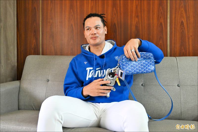 張育成的包包掛滿台灣隊回憶。（記者李惠洲攝）