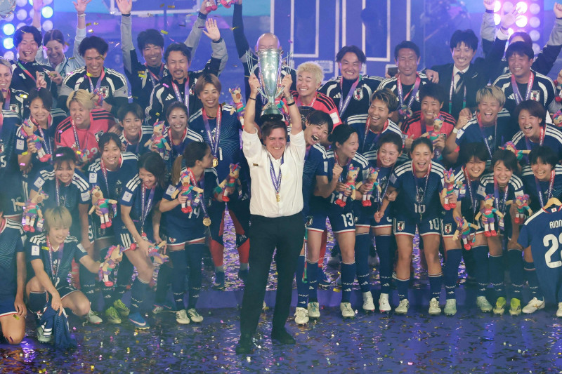 2026年3月21日，日本女足國家隊總教練尼爾森在歡慶奪冠的隊員的簇擁下，高舉女足亞洲盃冠軍獎杯。（法新社）