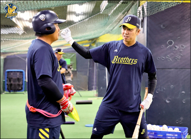 王威晨（右）與隊友一同檢討打擊策略。（中信兄弟提供）