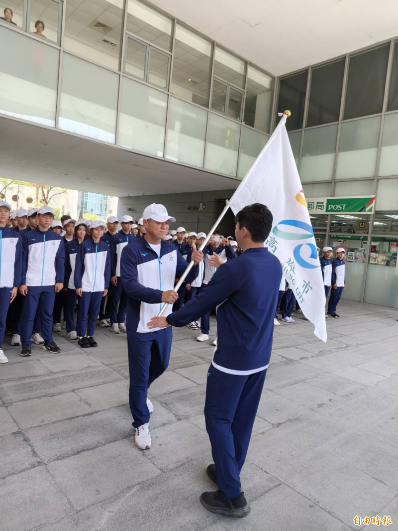 高雄市教育局長吳立森授旗給高雄市代表隊領隊田寮國中校長呂明信。（記者許麗娟攝）