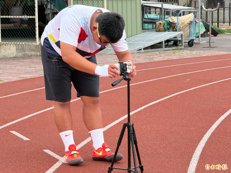 李健嘉練習時都會將自己投擲過程拍下，並針對姿勢不佳部分修正。（記者李文德攝）