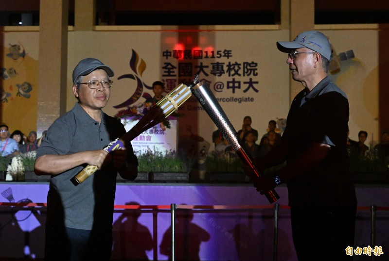 全大運聖火傳遞過程發生聖火罷工的插曲，中央大學前校長周景揚（右）傳遞給蕭述三校長時聖火一度熄滅（記者林正堃攝）
