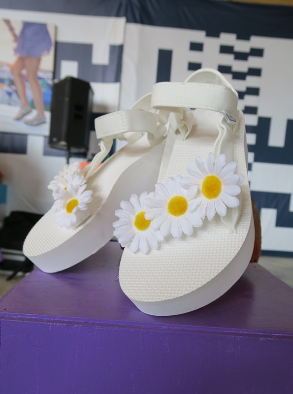 現場工作人員將音樂季經典花卉雛菊黏貼於鞋身。