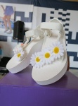 現場工作人員將音樂季經典花卉雛菊黏貼於鞋身。