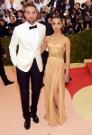 Robert Pattinson身穿Dior Homme西裝（左）、英國創作歌手FKA Twigs穿著Versace膚色皮革裝飾高衩訂製禮服。（右）（美聯社）