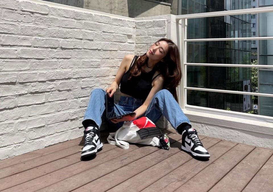 Tiffany 鏡頭前大方腿開開展現性感，與身上的牛仔褲、球鞋創造時尚反差。