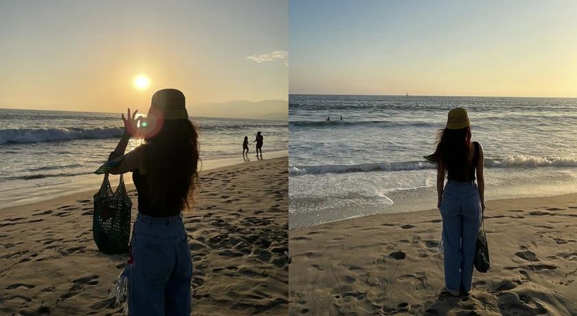 蔡依林看著夕陽海景，用手機紀錄畫面。