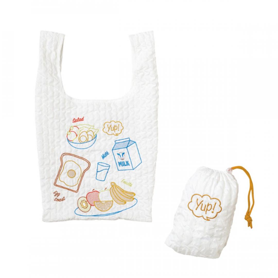 日本丸真yup! 創意收納環保袋-早餐時光，售價580元。包包圖案包含早餐三寶，荷包蛋、吐司、牛奶，擁有可愛的抓皺立體感設計，可折疊收納並附收納袋，外出攜帶更加便利。