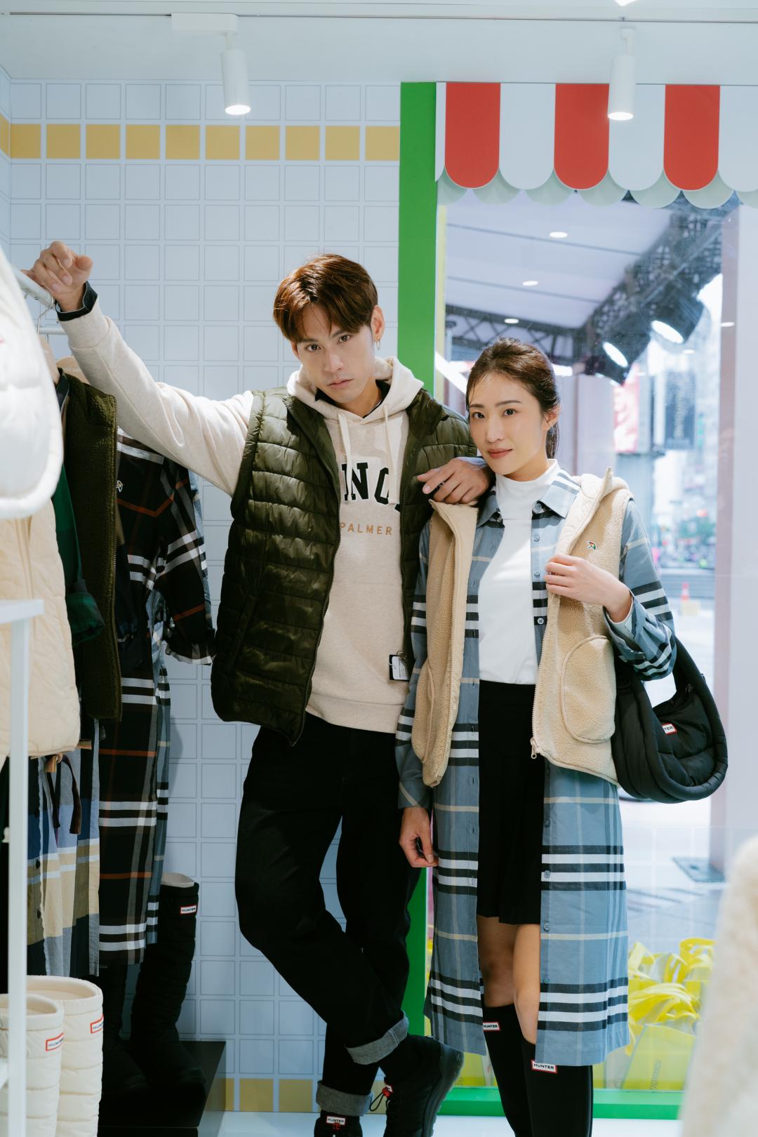 男模著Arnold Palmer連帽Tee（NT$3,450）搭配刷毛兩面穿連帽背心（NT$4,950）。女模著Arnold Palmer格紋長版襯衫（NT$3,950）搭配HUNTER布面長靴（NT$8,580）及迷你HOBO包（NT$3,480）。