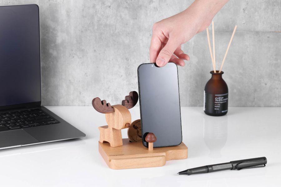 馴鹿手機座，優惠價500元，售價588元。精緻木製置物座，可放置手機與名片，以應景的馴鹿造型呈現，還設置造型小鹿幣，讓你在不知怎麼抉擇時都可以擲硬幣來抉擇Yes or No。